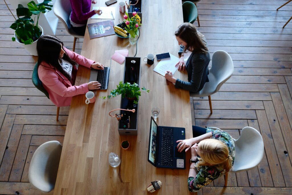 Una grande scriviania che accoglie le postazioni di lavoro di diversi dipendenti