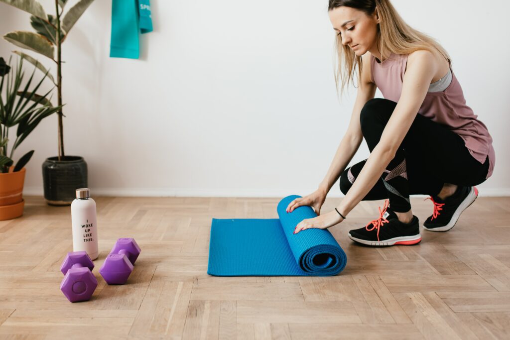Donna che arrotola un tappetino da palestra