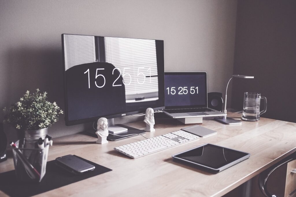 Scrivania da ufficio con monitor, laptop, smartphone e tablet di ultima generazione