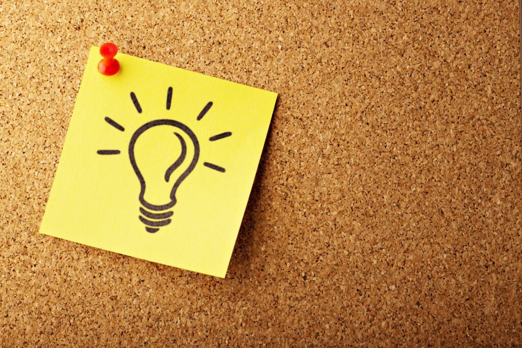 Post-it con il disegno di una lampandina appuntato su una bacheca